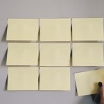 Post it notes on a wall are shown with one being taken off a wall. 75/25 Rule: Reminding vs. Teaching