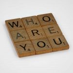 Pictured are scrabble block letters in shape of a square 3 by 3 that reads "Who are you". Today's episode is 5 Leadership Principles: Conversation with Paul Hanson, President of Epcon Franchising