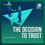Season 8 Episode 8: The Decision to Trust. Image of two people each on giant paper airplane wings about to shake hands bridging the gap while flying together.